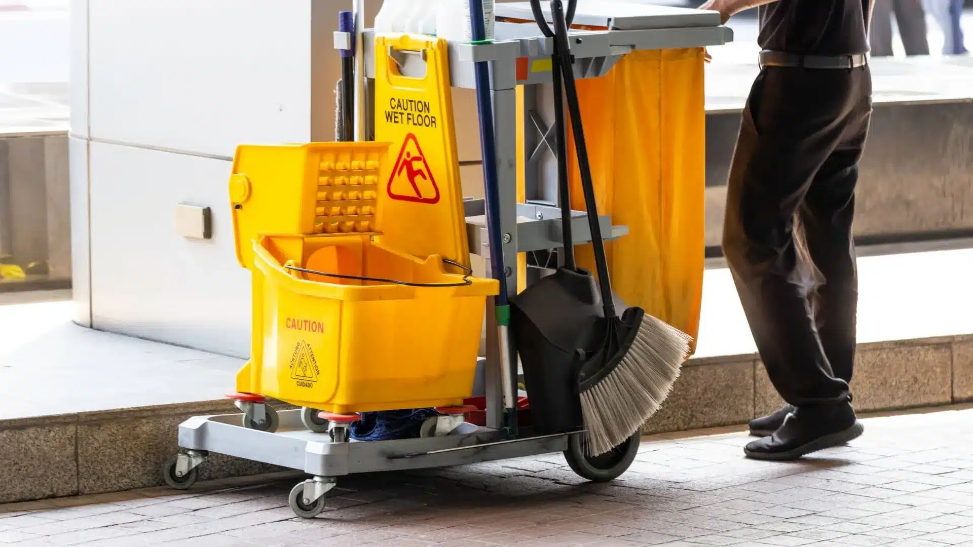Commercial day porter maintaining workplace cleanliness and restocking restroom supplies