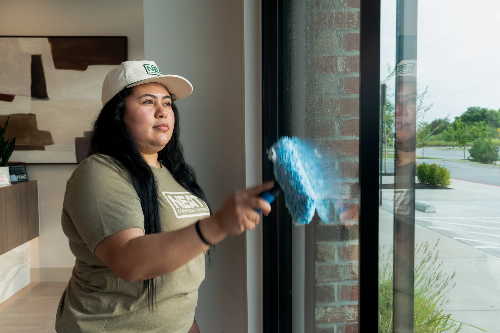 Team member cleaning interior office windows with microfiber cloth in Washington County, AR