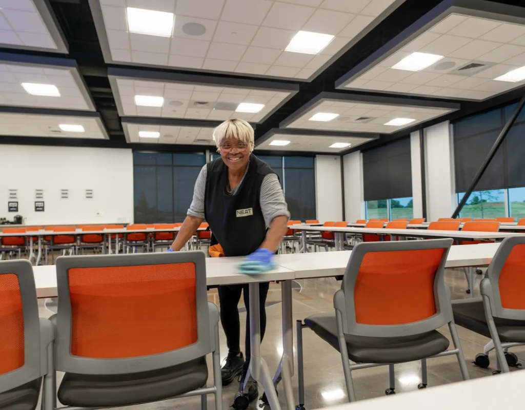 Team member wiping down event room tables during commercial cleaning in Benton County, AR