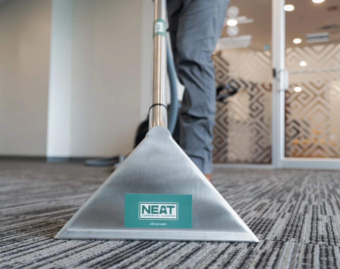 Close-up of hot water extraction carpet cleaning wand with Neat logo in Northwest Arkansas
