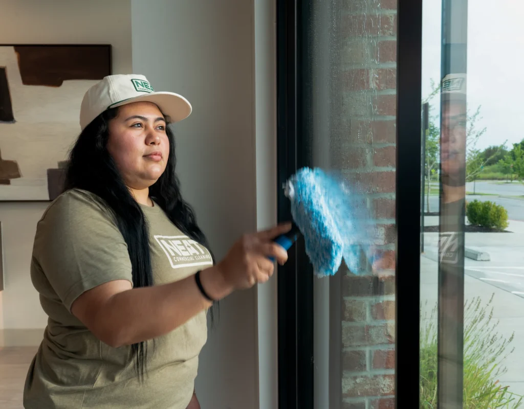 Team member cleaning interior office windows with microfiber cloth in Washington County, AR