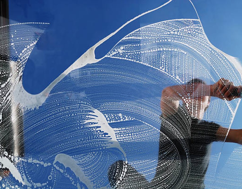 Streak free window cleaning service on storefront glass panels in daylight