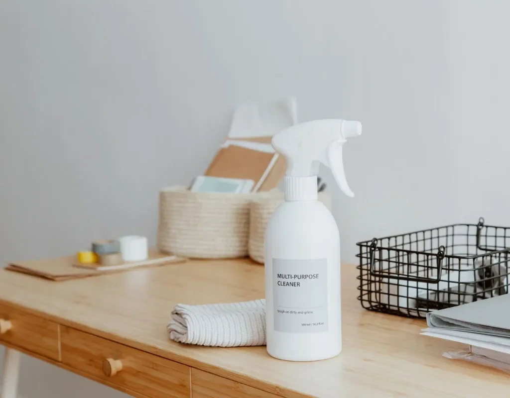 Disinfectant spray bottle and cleaning supplies on a medical office front desk in Rogers, AR. Medical Office Cleaning Near Me.